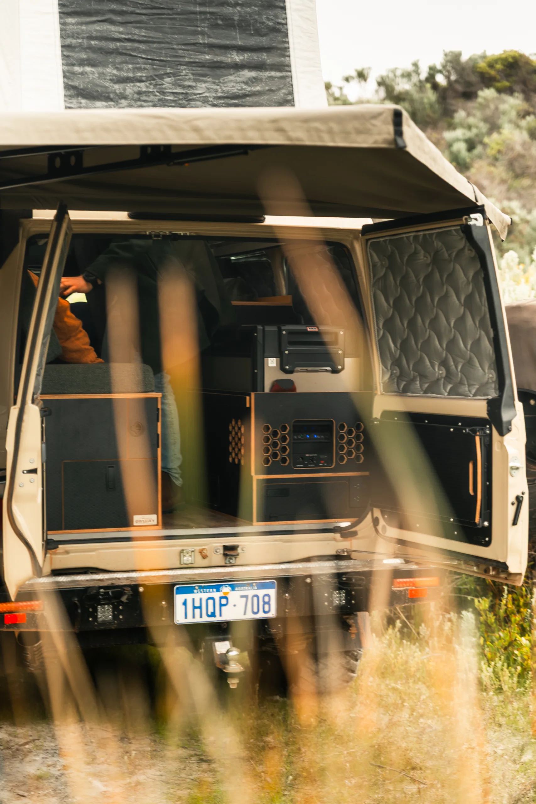 The rear of a Toyota Land Cruiser Troop Carrier with custom fit-out, including drawers, a fridge, and a power unit.