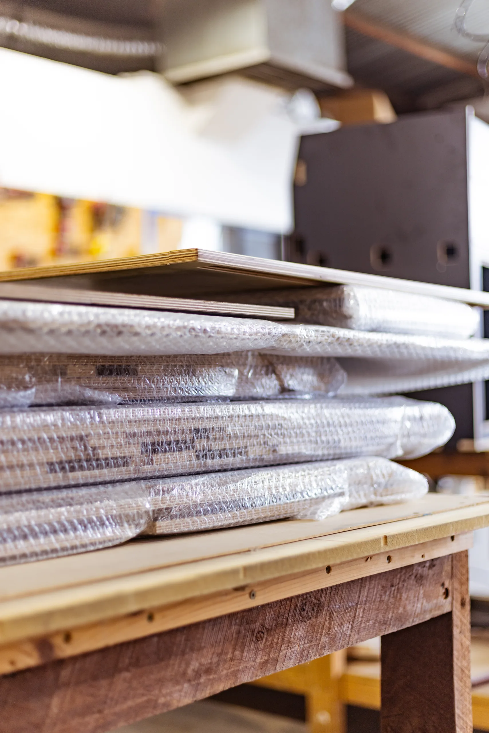 Odyssey flat-pack timber fit-outs stacked and wrapped in protective plastic.